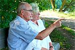 Senior couple talking on park bench