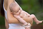 Mother stands holding 2 month old infant son