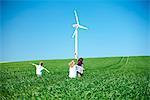 Wind turbine and childrens play in field