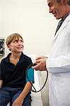 Doctor taking young boy's blood pressure