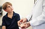 Doctor listening to young boy's pulse