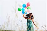 Woman with air balloons walking