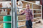 Boy with cow in barn