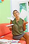 woman paying bills on couch