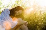 Portrait de femme assise dans l'herbe longue