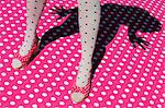 Frau trägt Polka Dot Strumpfhosen und Schuhe, die stehend auf Polka Dot-Oberfläche