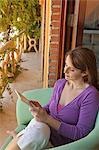 woman reading e-book on balcony
