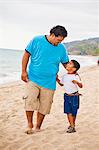 young mexican father and son on beach