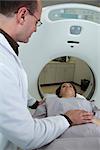 Doctor reassuring female patient preparing to undergo CAT scan