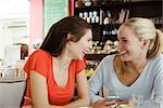 Female friends together at cafe, laughing