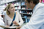 Young woman talking to pharmacist