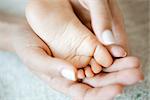 Woman's hands holding baby's foot