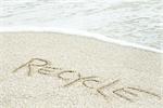 The word "recycle" written in the sand at the beach