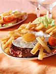 Hamburger with a fried egg on top and chips