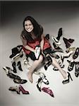 Overhead View of Woman Sitting on Floor Surrounded by Shoes