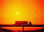 Dublin,Ireland;Truck Driving Over Bridge Silhouetted By Sunset