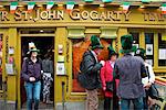 Dublin, Irland; Menschen versammelten sich vor einem Geschäft tragen große grüne Hüte für St. Patrick's Day