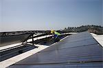 Maintenance worker checks solar array on rooftop in Los Angeles, California