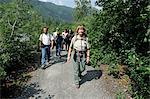 Female Forest Service guide leading hikers on a trail to Spencer Glacier as part of the Alaska Railroad's Spencer Whistle Stop Camping tour, Southcentral Alaska, Summer