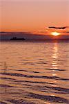 View of cargo ship sailing up Knik Arm towards the Port of Anchorage at sunset, Southcentral, Alaska, Summer