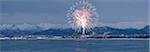 Panormic view of moon rising over the Anchorage skyline and Chugach Mountains at sunset with  fireworks overhead as seen from Point Woronzof, Southcentral Alaska, Winter, COMPOSITE