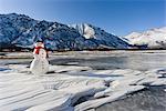 Bonhomme de neige avec un foulard rouge et un chapeau noir, assis sur la rivière gelée de Nenana avec les contreforts de la chaîne de l'Alaska à l'arrière-plan, le centre-sud de l'Alaska, hiver