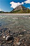 View of North Fork Koyukuk River flowing over a rocky gravel bar with Frigid Crags in the background,  Gates of the Arctic National Park & Preserve, Arctic Alaska, Summer