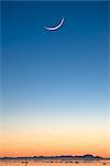 Cresent moon rising au coucher du soleil sur Cook Inlet près du parc de la baie de sureau, Anchorage, Alaska du centre-sud, l'hiver, COMPOSITE