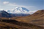 A camper travels down the Park Road near Stony Hill with Mt. McKinley in the background, Denali National Park, Interior Alaska, Fall