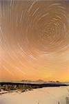 Night time view of star trails over Mt. McKinley with Northern Lights in the background, Denali State Park, Southcentral Alaska, Winter