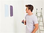 Jeune homme avec de la peinture sur le mur