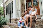 Familie sitzen auf Haus Schritte