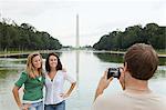 Young man taking photograph of friends at washington monument