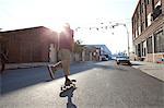 Skateboarder on urban street in sunlight