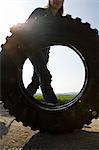 Woman rolling tire to recycle