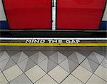 Mind the gap warning painted on the edge of the subway platform in the London Underground