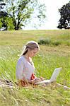 Young woman using laptop computer in park