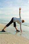Femme faisant du yoga sur la plage