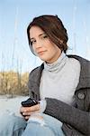 Teen girl text messaging at the beach, portrait