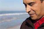 Man at the beach looking down in thought, portrait