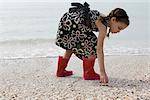 Fille, ramasser des coquillages sur la plage