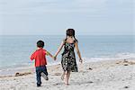 Children running together at the beach, holding hands