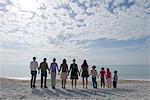 Gruppe von Menschen am Strand stehen, Hand in Hand