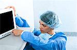 Surgeon adjusting monitor in operating room