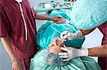 Chirurgien avec scalpel sur le visage du patient.
