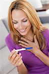 young woman holding pregnancy test