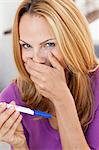 young woman holding pregnancy test