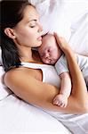 Woman and her baby sleeping in bed