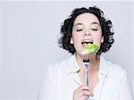 woman holding fork with leaf of salad