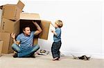 Father and son playing with moving boxes